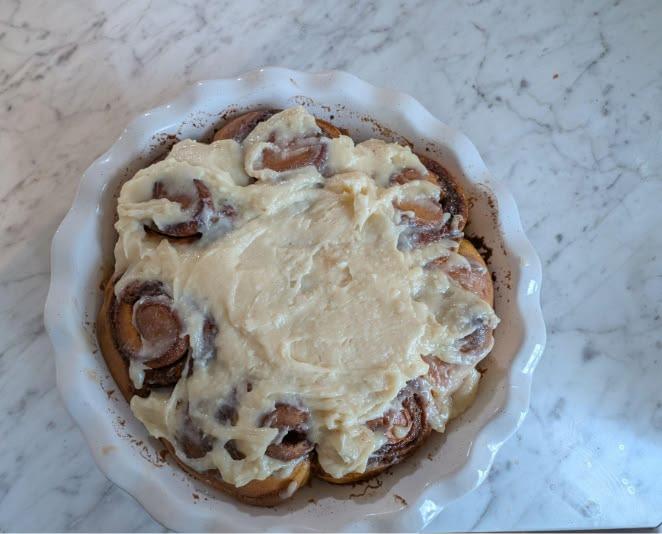 Freshly baked sweet potato sourdough cinnamon rolls in a baking dish.