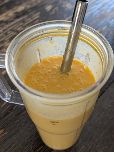 Creamy orange smoothie served cold in a glass.